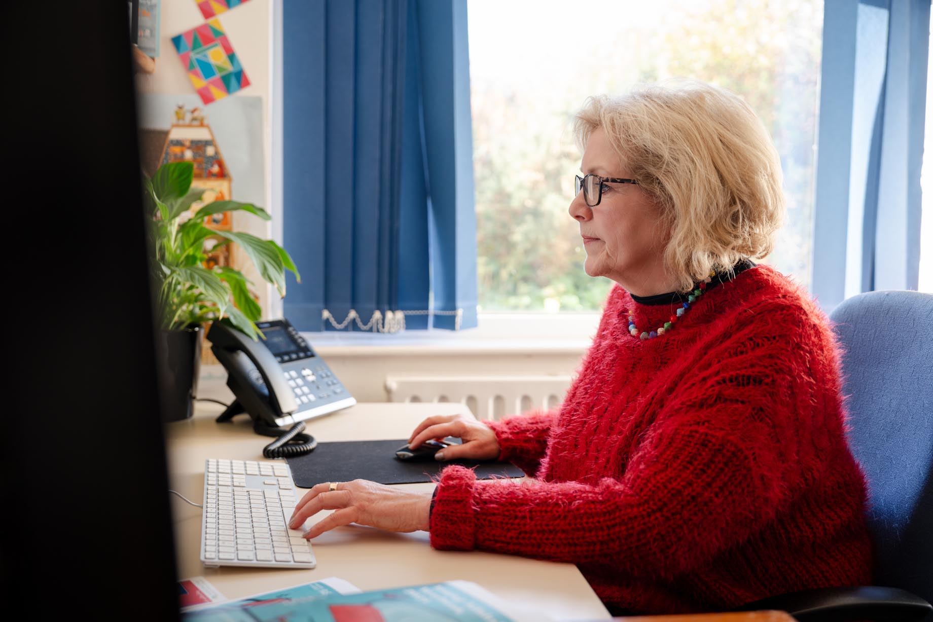 A designer at her desk working on a computer.
