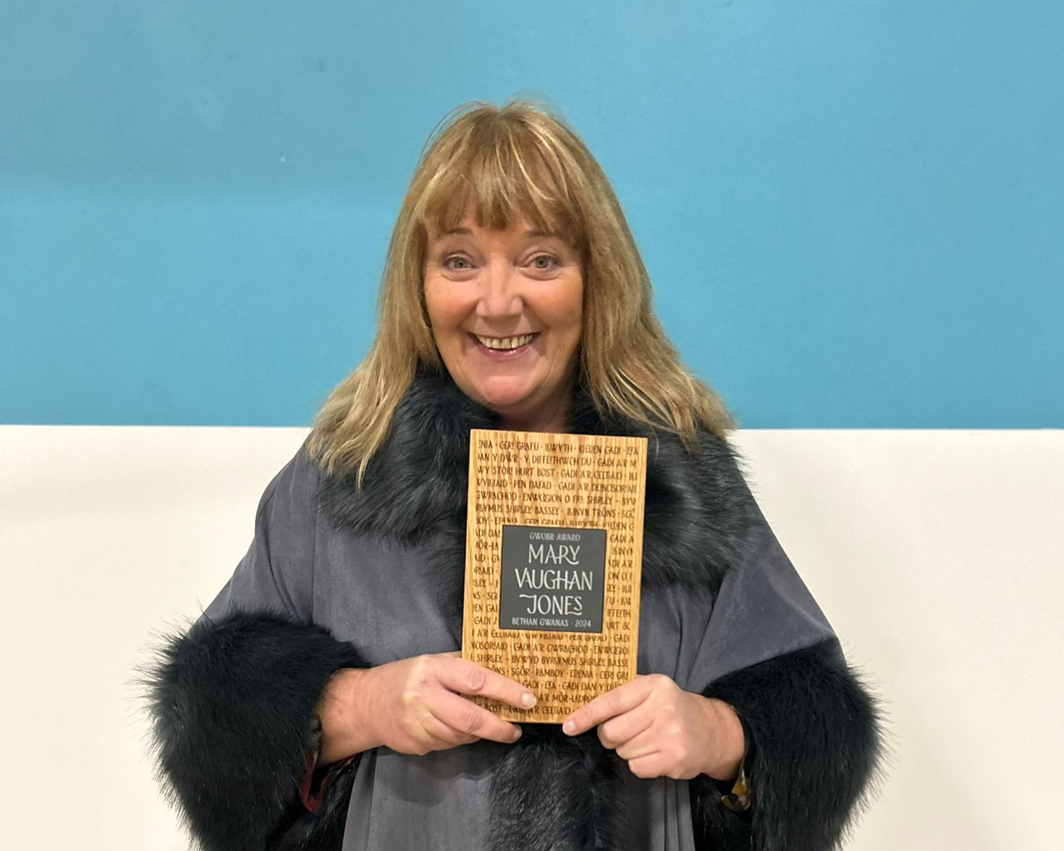 Gwobr-Mary-Vaughan-Jones—Bethan-Gwanas Bethan Gwanas poses with her Mary Vaughan Jones award in 2025.