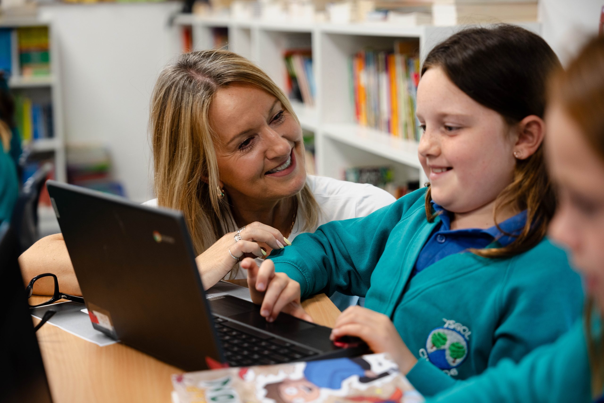 547_ffN_CyngorLlyfrau_603 Dysgwr ac athrawes yn gweithio gyda'i gilydd ar liniadur yn y dosbarth Pupil and teacher working together on a laptop in the classroom